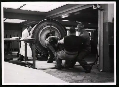 Fotografie Louis Kunz, Männedorf, Stahl-Walzwerk, Arbeiter richten eine Trommel mit Stahlblech aus