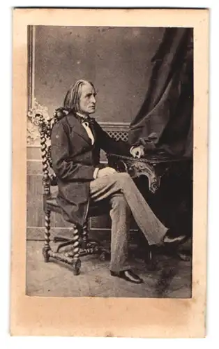 Fotografie unbekannter Fotograf und Ort, Portrait Franz Liszt im Anzug am Tisch sitzend