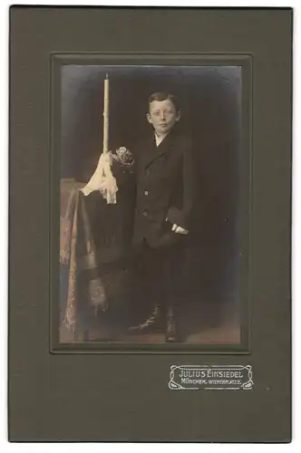 Fotografie Julius Einsiedel, München, Wienerplatz 2, Portrait junger Knabe im Anzug mit Kommunionskerze