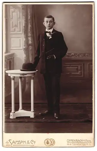 Fotografie Samson & Co., Offenbach a. Main, Portrait junger Knabe im Anzug mit Melone zur Kommunion