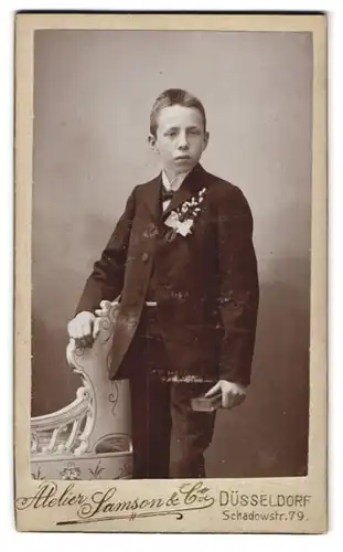 Fotografie Samson & Co, Düsseldorf, Schadowstr. 79, Portrait junger Knabe im Anzug mit Ansteckblume, Kommunion