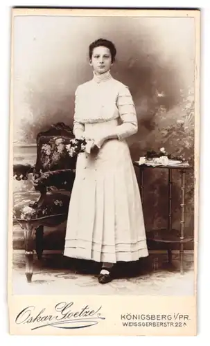 Fotografie Oskar Goetze, Königsberg i. Pr., Weissgerberstr. 22, Portrait junge Frau im Kommunionskleid mit Blumenstrauss