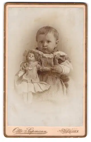 Fotografie Otto Siepmann, Iserlohn, kleines Kind im karierten Kleid mit Puppe im Arm