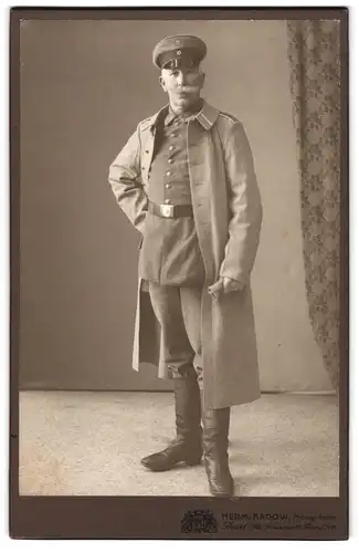 Fotografie Herm. Kadow, Beuel a. Rh., Brückenstr. 10, Portrait älterer Uffz. in Uniform Rgt. 22 mit Mantel