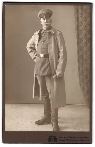 Fotografie Herm. Kadow, Beuel a. Rh., Brückenstr. 10, Portrait Uffz. in Feldgrau Uniform Rgt. 22 mit Mantel