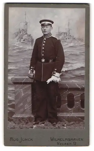 Fotografie Aug. Junck, Wilhelmshaven, Neuestr. 12, Offizier in Uniform II. Seebataillon vor einer Studiokulisse