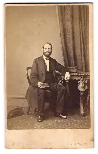 Fotografie Maliby & Co., London-Islington, Barnsbury Hall, Portrait modisch gekleideter Herr mit einem Buch