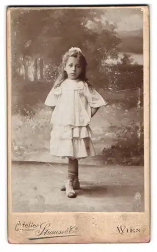 Fotografie Atelier Strauss & Co., Wien, Kohlmarkt 5, Portrait kleines Mädchenin weisser Kleidung