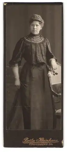 Fotografie Berta Kleinhans, Königsberg, Frau mit hochgesteckten Haaren und Blume in der Hand