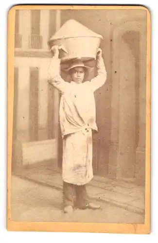 Fotografie unbekannter Fotograf und Ort, junger Südamerikanischer Bäckers Junge mit Zuckerkorb auf dem Kopf