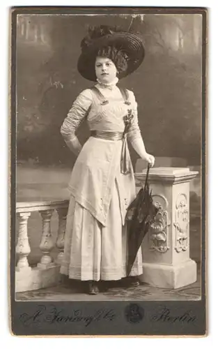 Fotografie A. Jandorf & Co., Berlin, Portrait junge Frau im hellen Kleid mit breitem Hut und Schirm