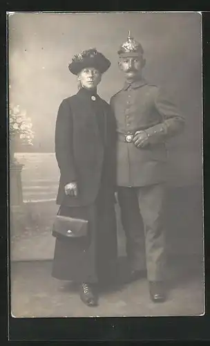 Foto-AK Soldat in Uniform mit Pickelhaube und Frau, Uniformfoto