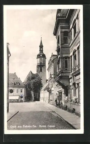 AK Pulsnitz /Sachsen, Strassenpartie Kurze Gasse mit Kirche und Passanten