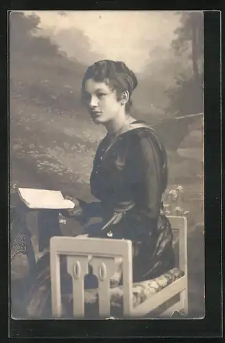 AK Junge Frau lesend auf einer Bank sitzend