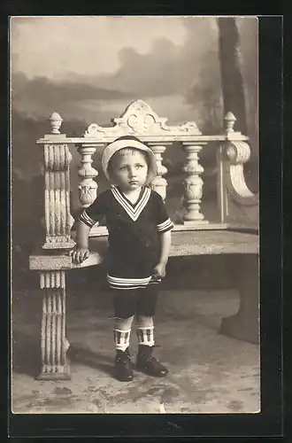 Foto-AK Kleiner Junge im Matrosenanzug in einer Studiokulisse