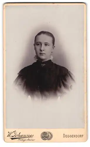 Fotografie W. Johannes, Deggendorf, Junge Frau im schwarzen Kleid mit Kragenbrosche