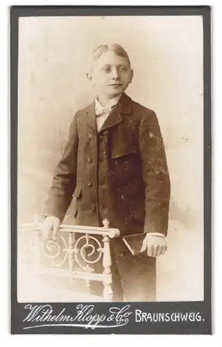 Fotografie Wilhelm Klopp & Co., Braunschweig, Portrait junger Mann im Anzug mit Fliege