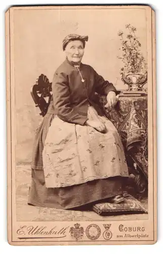 Fotografie E. Uhlenhuth, Coburg, Am Alberplatz, Ältere Dame mit Kopftuch und Schürze