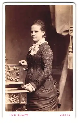 Fotografie Franz Neumayer, München, Neuhauserstrasse 29, junge Frau im Kleid, an Sekretär lehnend