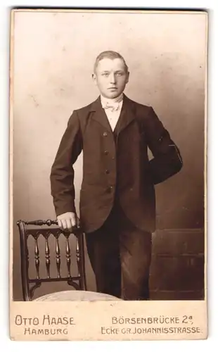 Fotografie Otto Haase, Hamburg, Börsenbrücke 2a, junger Herr im Anzug auf Stuhl lehnend