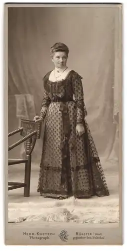 Fotografie H. Knetsch, Münster, Dame im feinen Kleid, an Stuhl lehnend