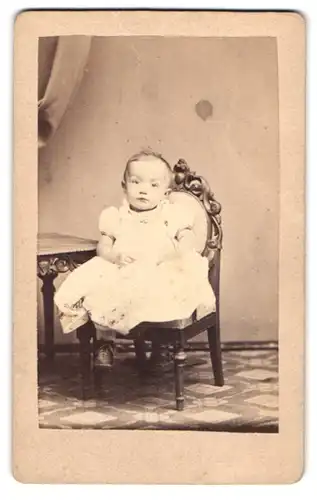 Fotografie M. Ackermann, Görlitz, Schützenweg 2, Portrait kleines Kind im weissen Kleid auf einem Kinderstuhl