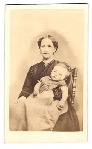 Fotografie unbekannter Fotograf und Ort, Portrait junge Mutter Züllickau mit ihrem Kinde auf dem Schoss