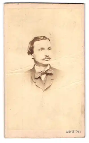 Fotografie Adolf Ost, Wien, Wollzeile 34, Portrait junger Mann im Anzug mit Fliege und Moustache