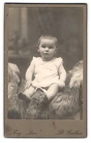 Fotografie Aug. Bär, St. Gallen, Singenbergstrasse 1, Portrait, Kleinkind im Pelz sitzend