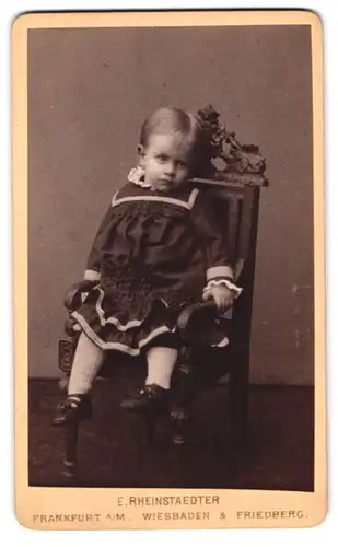 Fotografie E. Rheinstaedter, Frankfurt a. M., Hochstrasse 32, Kleinkind auf Stuhl sitzend