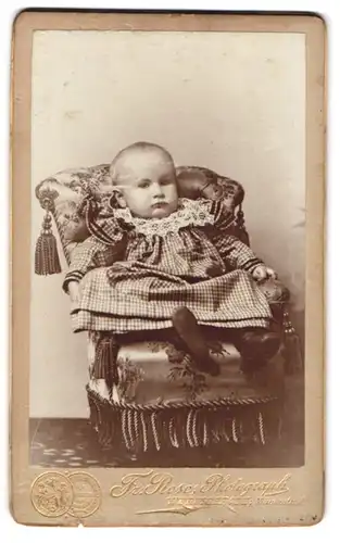Fotografie Fr. Rose, Wernigerode, Mühlensthal, Baby im karrierten Kleid auf einem kleinen Sessel
