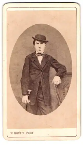 Fotografie W. Boppel, Schw. Gmünd, Bursche mit schiefer Melone und Gehstock im Anzug
