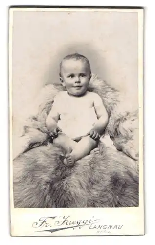 Fotografie Fr. Jaeggi, Langnau, Kleinkind mit nackten Füssen auf Pelz