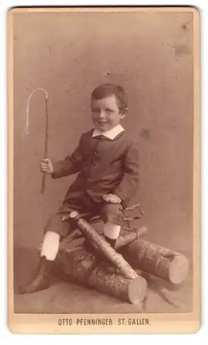Fotografie Otto Pfenninger, St. Gallen, Grinsender Junge mit Peitsche