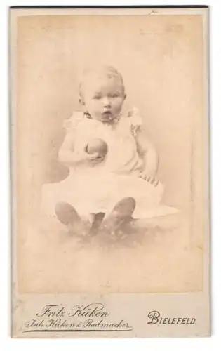 Fotografie Fritz Küken, Bielefeld, Neumarkt 20, kleines Mädchen im weissen Kleid mit Ball in der Hand