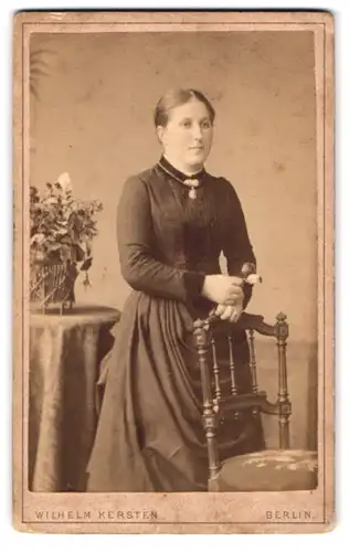 Fotografie Wilhelm Kersten, Berlin, Krausen-Str. 40, Frau im schwarzen Kleid mit Blumen in der Hand