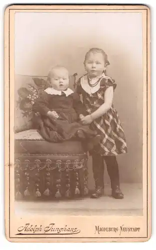 Fotografie Adolph Junghans, Magdeburg-Neustadt, Breiteweg 21, Kleines Mädchen im karierten Kleid mit Kleinkind