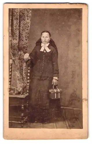 Fotografie unbekannter Fotograf und Ort, Portrait Dame im Trachtenkleid mit Köfferchen in der Hand