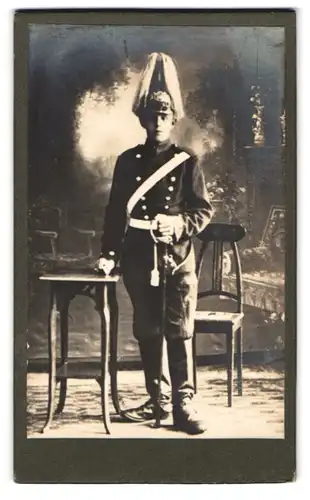 Fotografie unbekannter Fotograf und Ort, Portrait junger Soldat in Uniform mit Pickelhaube Rosshaarbusch und Säbel