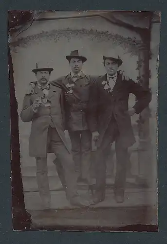 Fotografie Ferrotypie drei junge Herren in Anzügen auf einer Kirmes mit Orden und Zetteln am Hut