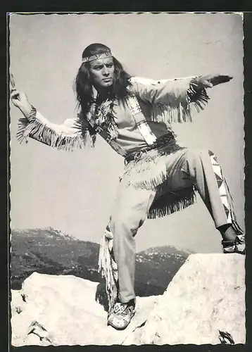 AK Schauspieler Pierre Brice als Winnetou schwingt seinen Tomahawk