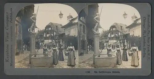 Fotografie Keystone View Comp. Meadville / PA., Frauen in Trachtenkleidern am Dorfbrunnen in der Schweiz