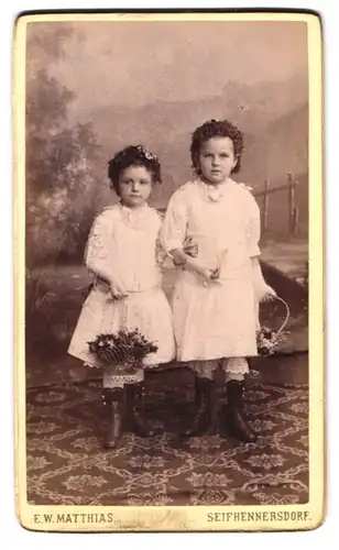 Fotografie E. W. Matthias, Seifhennersdorf, Portrait zwei niedliche Mädchen mit Blumenkörben