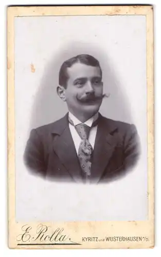 Fotografie E. Rolla, Kyritz, Portrait charmanter Herr mit Schnurrbart und Krawatte im Jackett