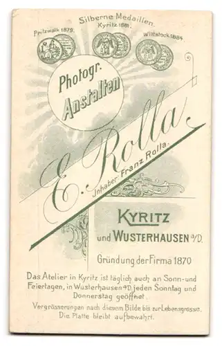 Fotografie E. Rolla, Kyritz, Portrait blondes niedliches Kleinkind im weissen gerüschten Kleidchen