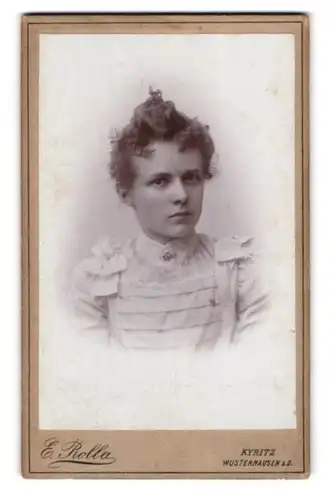 Fotografie E. Rolla, Kyritz, Portrait bildschönes Fräulein mit Dutt in weisser gerüschter Bluse