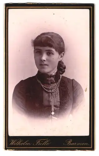 Fotografie Wilhelm Fülle, Barmen, Neuenweg 50, Portrait dunkelhaariges hübsches Mädchen mit Flechtzopf