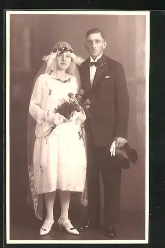 AK Junges Brautpaar in eleganter Hochzeitsmode mit Schleier, Zylinder und Blumen