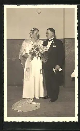 AK Verliebtes Brautpaar mit Blumenstrauss in Hochzeitsmode