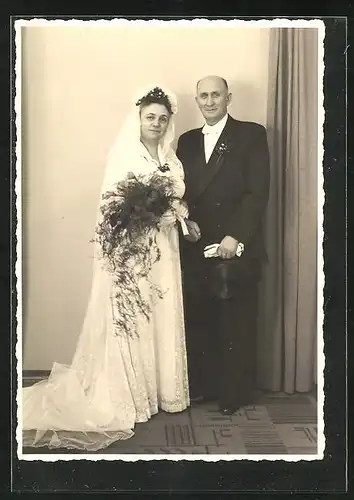 AK Portrait eines elegant gekleideten Brautpaares mit Blumenstrauss